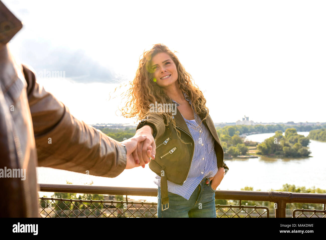 Attraente lunghi capelli donna tirando i suoi fidanzati mano che desiderano venire insieme con lei. Tenendo la mano Foto Stock