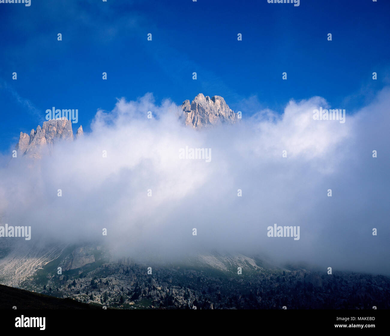 Il cloud e la nebbia che turbinano intorno le scogliere del Sassolungo Cinque Dita Grohmannspitze e Sasso Piatto Selva Passo Sella Val Gardena Dolomiti Alto Adige Foto Stock