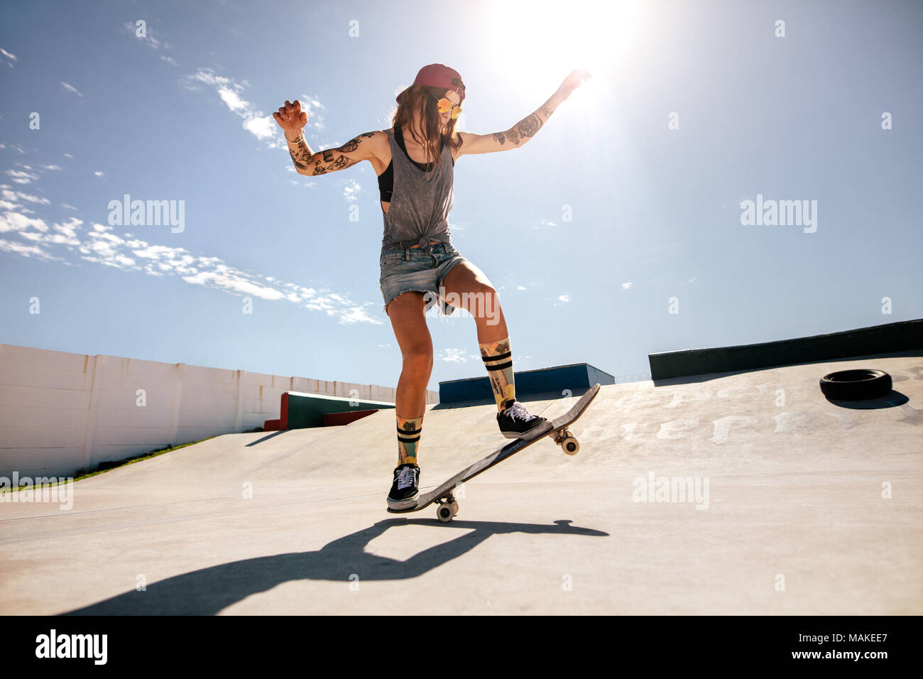 Skater femmina lo skateboard a skate park. Le donne di fare trucchi su skateboard. Foto Stock