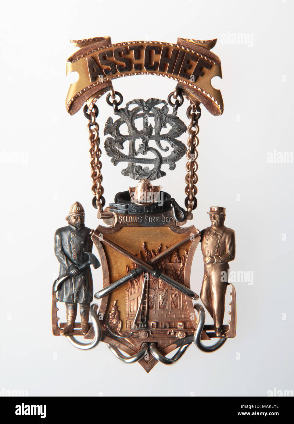 Oro medaglia scolpita; scudo con rilievo applicato raffigurazione di Hotel fire; argento attraversato i tubi flessibili attraverso scudo; scudo affiancato da figure scolpite; barra multifunzione il pin può contenere lamine monogram Titolo: medaglia commemorativa da San Luigi dei Vigili del Fuoco ha presentato a John F. Barry . 1886. Foto Stock