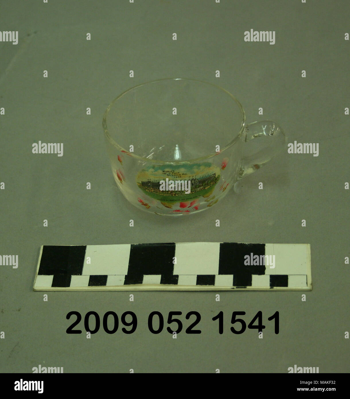 In vetro trasparente cup ha colore immagine di trasferimento del palazzo di educazione e di economia sociale e dipinto di rosa fiori. Questo souvenir da 1904 Fiera Mondiale è personalizzato per Mimmie M. Schmidt Titolo: chiaro vetro tazza personalizzata per Mimmie M. Schmidt con trasferimento di colore immagine del palazzo di istruzione e di economia sociale . 1904. Foto Stock