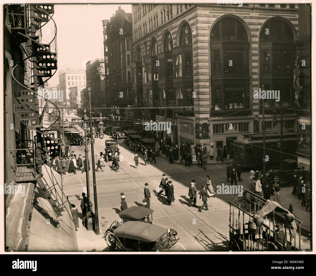 In orizzontale e di fotografia in bianco e nero dell'incrocio occupato a Sesto e pino. Le persone si spostano lungo le strade e marciapiedi e le automobili sono parcheggiate o la guida lungo la strada. Un carrello è fermo a destra della fotografia. La fila di edifici commerciali ospita più aziende come Jamerson abbigliamento, scarpe di Hannover, Regal, Werner e Werner, Schaper, e il nuovo Hotel Barnum. Titolo: Sesto e pino. . Circa 1915. Swekosky, William G., 1895-19643 Foto Stock