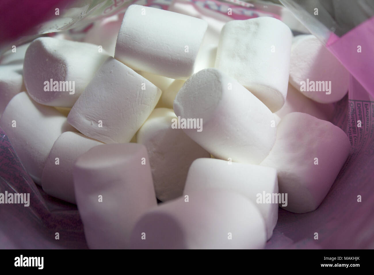 Pila di soffice bianco marshmallows interno pacchetto rosa Foto Stock
