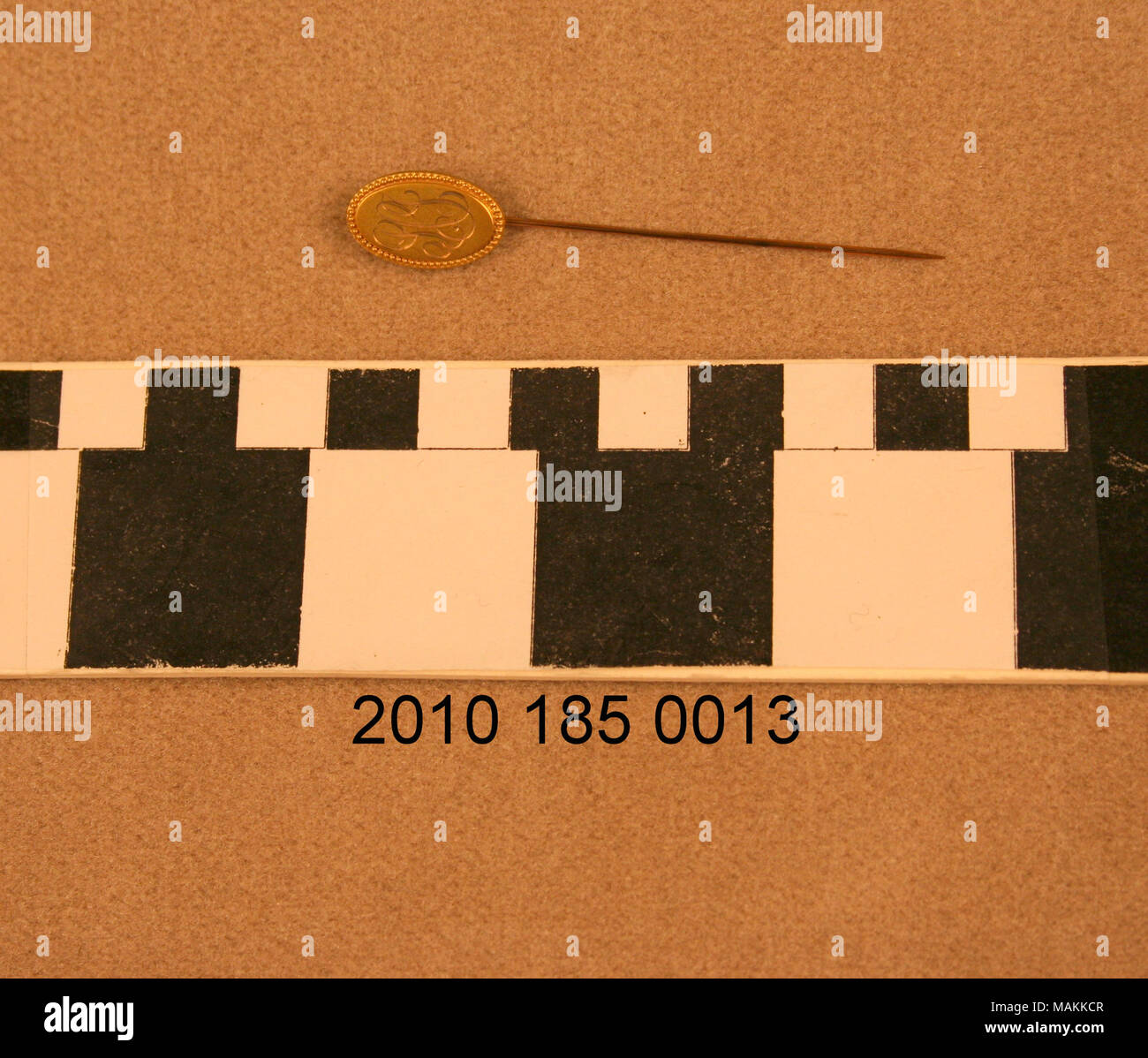 Stickpin con testa di oro e ornati monogramma decorativo. Titolo: oro ovale testa a Stickpin . circa 1861. Foto Stock