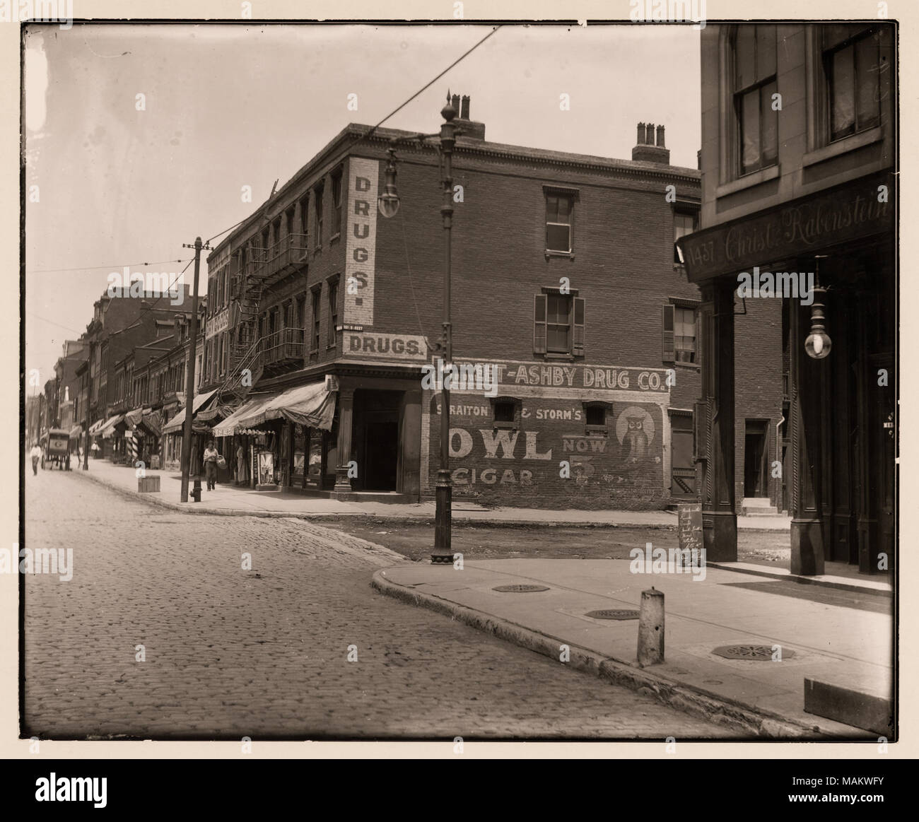 In orizzontale e di fotografia in bianco e nero dell'intersezione del quindicesimo e Franklin strade. Mattone di edifici commerciali la linea i marciapiedi. Annunci per "Gufo" di sigari e di droga sono dipinte sul lato dell'edificio. Titolo: quindicesimo e Franklin intersezione. . Tra circa 1800 e circa 1900. Swekosky, William G., 1895-1964 Foto Stock