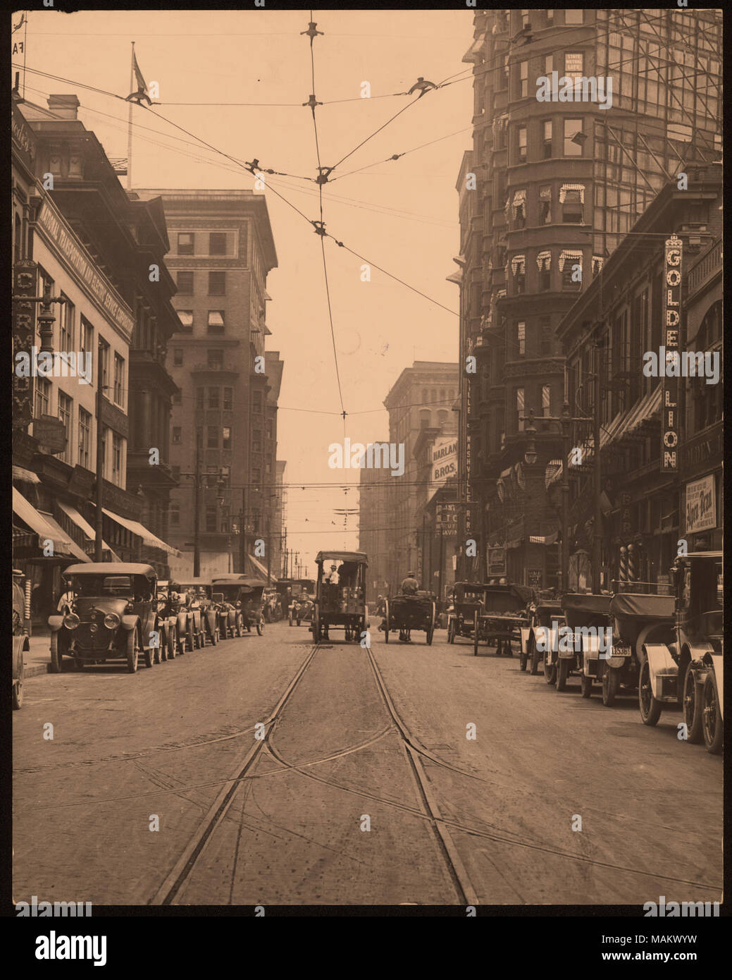 Verticale, fotografia in bianco e nero di una Street View di otto e strade di pino. La costruzione di edifici commerciali la linea di entrambi i lati della strada e i carri trainati da cavalli e carri si muovono verso il centro della strada. I carrelli e le automobili sono parcheggiate su entrambi i lati della strada. Segni pubblicizza per 'Carmody', 'Golden Lion', 'Harlan Bros.' e 'trasporti nazionali e il servizio elettrico Corporation". Titolo: ottavo e strade di pino. . Tra circa 1800 e circa 1900. Swekosky, William G., 1895-1964 Foto Stock