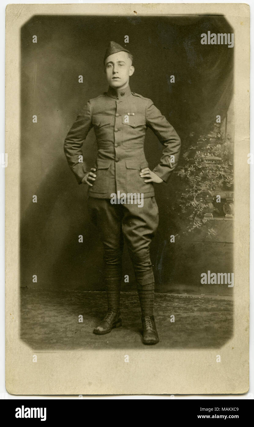 Verticale, seppia Cartolina che mostra un uomo vestito in uniforme militare che posano per una foto formale in un studio impostazione. Titolo: soldato che posano per una foto formale in un studio impostazione. . Tra circa 1916 e circa 1918. Foto Stock