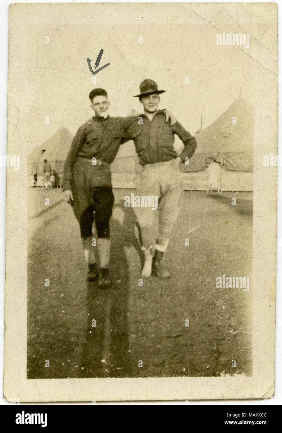 Verticale, seppia fotografia che mostra due soldati in uniforme che posano per una foto insieme. Le tende sono visibili in background. Una freccia è stato disegnato sulla foto, puntando verso il soldato sul lato sinistro. Scritto sul retro della fotografia è il nome 'Harry." Titolo: due soldati che posano per una foto insieme. . Tra circa 1916 e circa 1918. Foto Stock