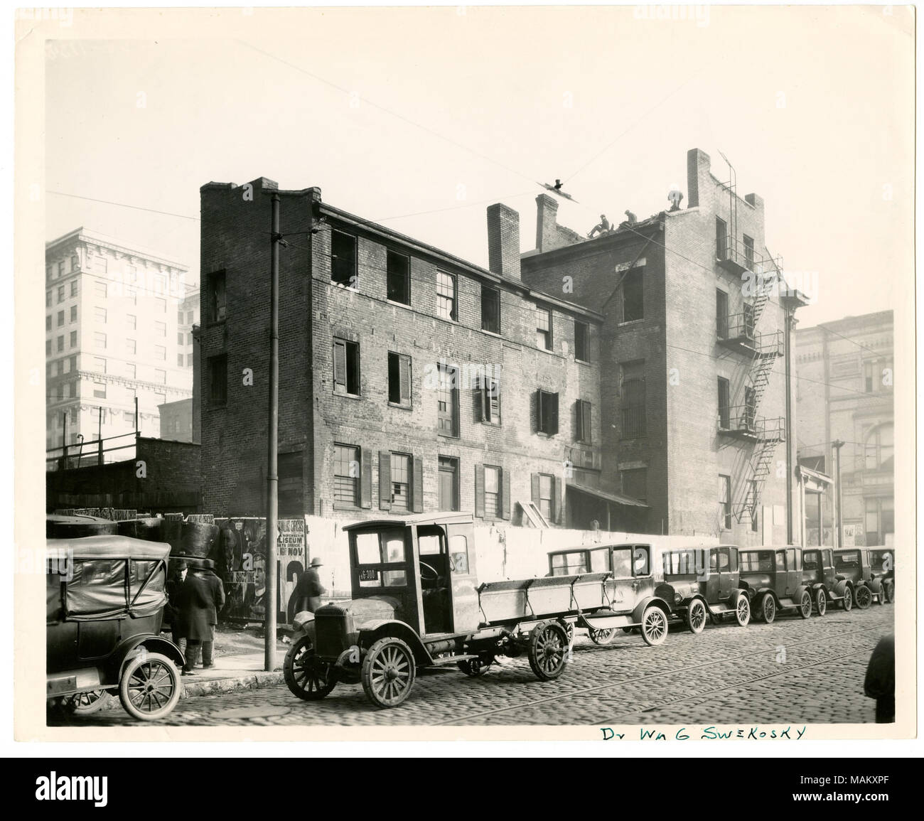 In orizzontale e di fotografia in bianco e nero che mostra un vista posteriore P. E. Burke's Bar all'angolo nord-ovest di 7th Street e noce, ex Francesco P. Blair residence. Più del terzo piano di windows sono mancanti. Una via di fuga in caso di incendi viene eseguito dai piani superiori verso il basso sul lato dell'edificio. Le auto sono parcheggiate parallele lungo il cordolo e molti pedoni può essere visto nella parte anteriore dell'edificio. Una nota manoscritta lungo il bordo inferiore si legge: 'Dr Wm G Swekosky." vedere il retro della stampa per le note manoscritte dal dottor William G. Swekosky per quanto riguarda la successione di proprietà dell'edificio. È stato bui Foto Stock