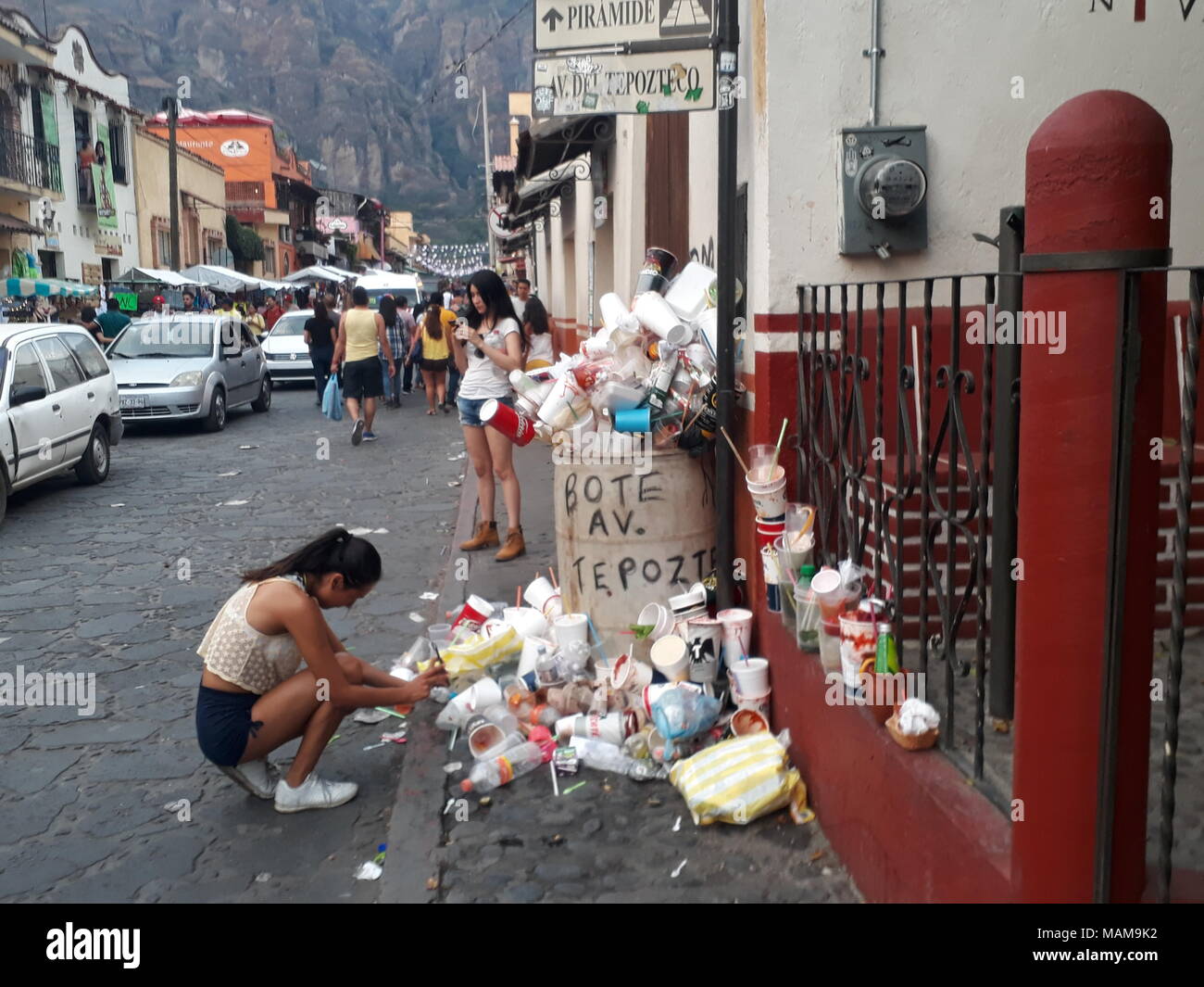 Tepoztlan, MORELOS, Messico. Xviii Mar, 2018. Una giovane donna si vede il deposito di rifiuti in contenitori per rifiuti supera la loro capacità, nonostante il grande afflusso di turismo a Tepoztlan le autorità locali non soddisfano le esigenze di evitare inquinamento e mantenere le strade pulite. Credito: Carlos Tischler SOPA/images/ZUMA filo/Alamy Live News Foto Stock