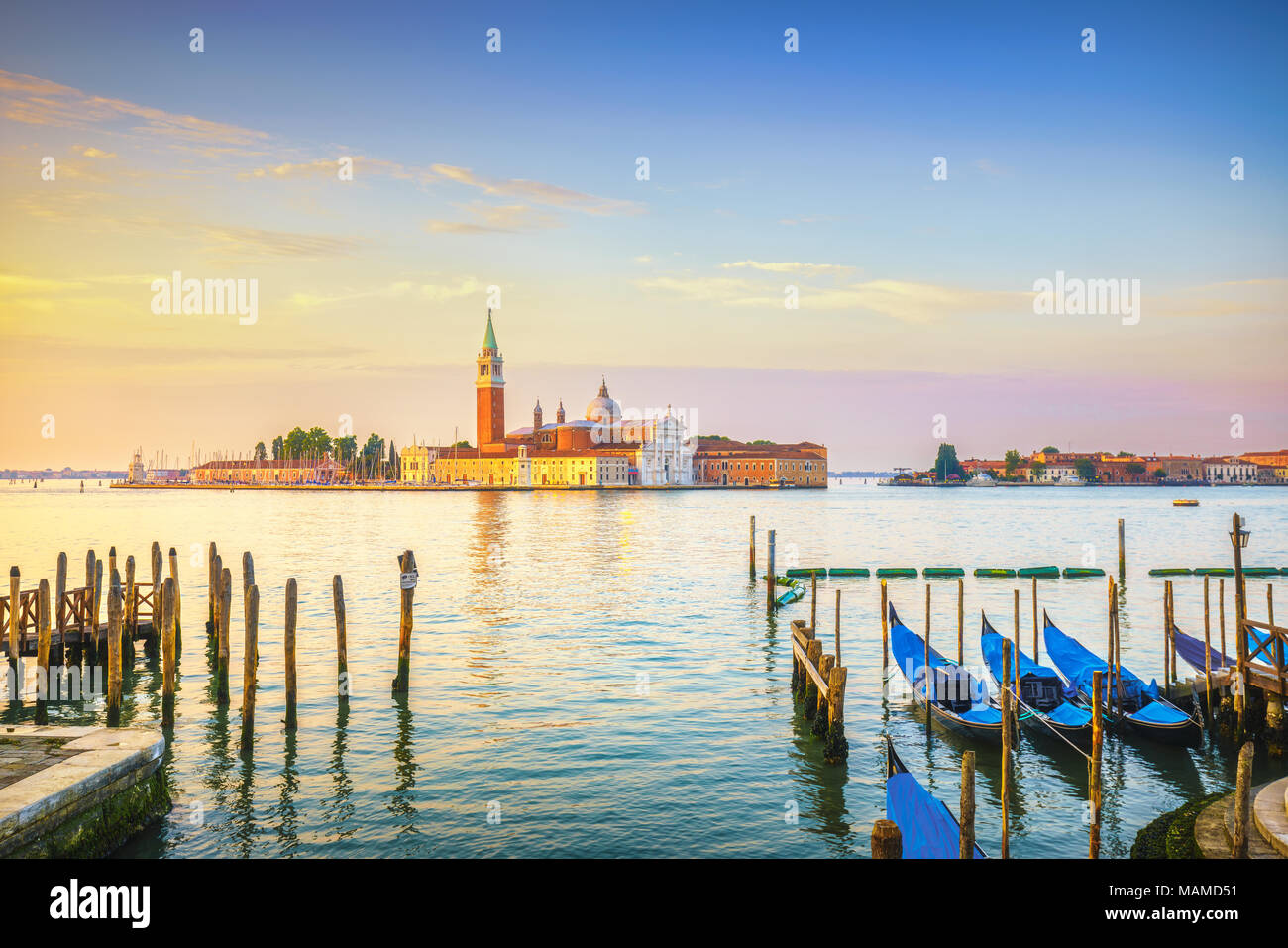 La laguna di Venezia al sunrise, chiesa di San Giorgio Maggiore, le gondole e i poli. L'Italia, l'Europa. Foto Stock