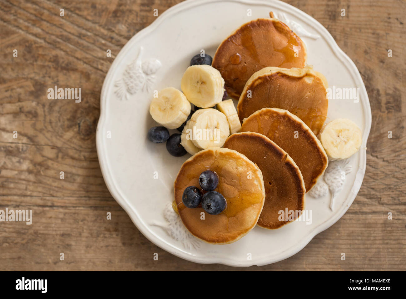 Ottima Colazione Vista Superiore Colpo Di Pancake Con Fette Di Banana E Mirtilli In Una Piastra Rustico In Legno Sul Piano Portapaziente Foto Stock Alamy