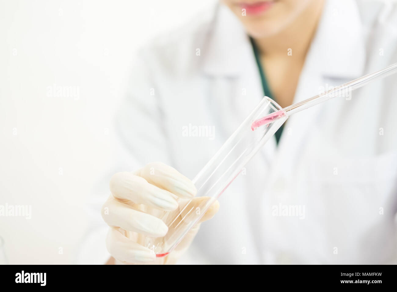 Giovani asiatici scienziato che lavora nel lavabo con provette e altre attrezzature per scoprire nuovi farmaci, prodotti e metodi di formulazione Foto Stock