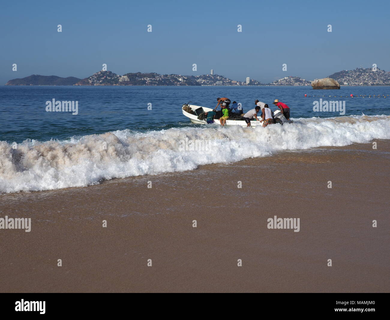Imbarcazione a motore usato per la pesca e le escursioni turistiche della baia di oceano Pacifico in Acapulco in Messico, spiaggia sabbiosa paesaggio Foto Stock