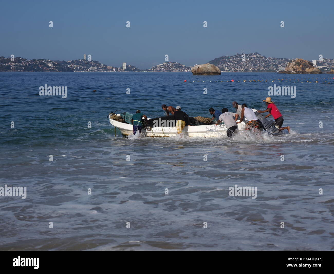 Imbarcazione a motore usato per la pesca e le escursioni turistiche della baia di oceano Pacifico in Acapulco in Messico alla spiaggia sabbiosa del paesaggio Foto Stock