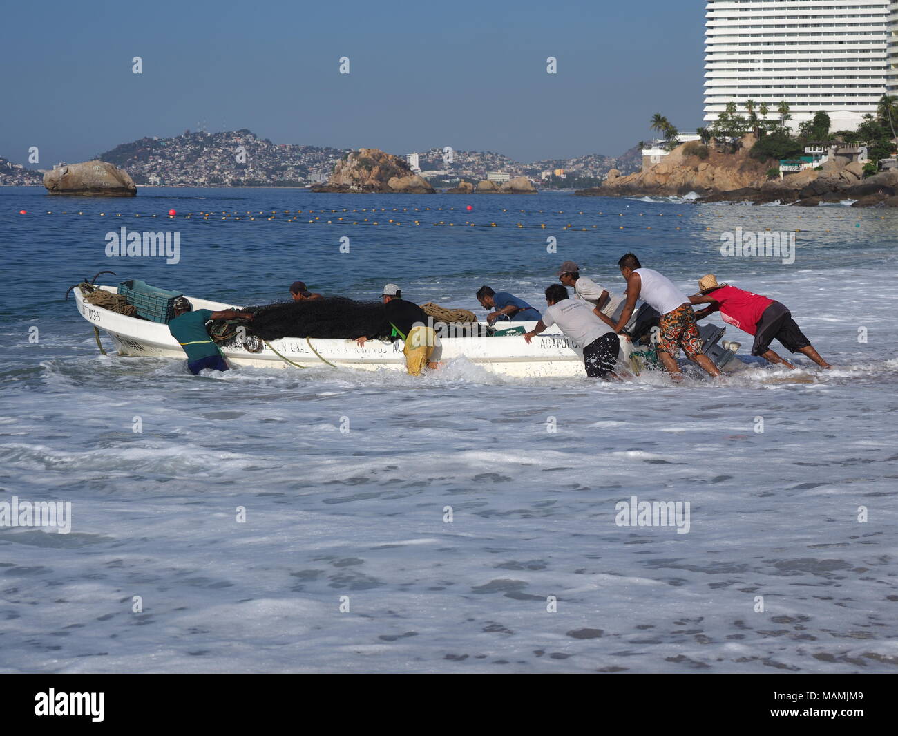 Imbarcazione a motore usato per la pesca e le escursioni turistiche dell Oceano Pacifico baia di Acapulco in Messico, spiaggia sabbiosa paesaggio Foto Stock