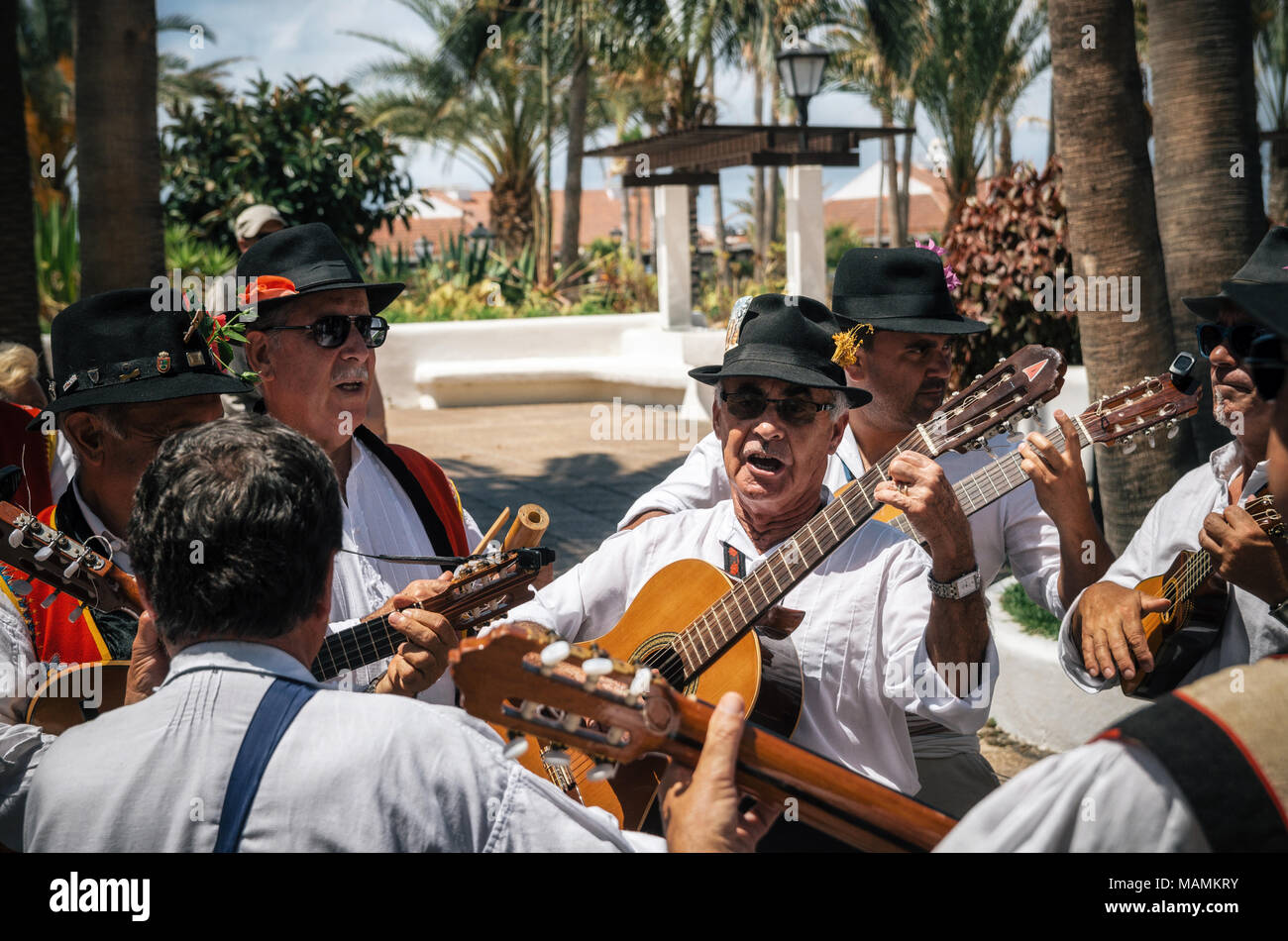 Puerto de la Cruz Tenerife Isole Canarie - Maggio 30, 2017: Canarie persone vestite con abiti tradizionali a piedi lungo la strada, firmare e a suonare la chitarra Foto Stock