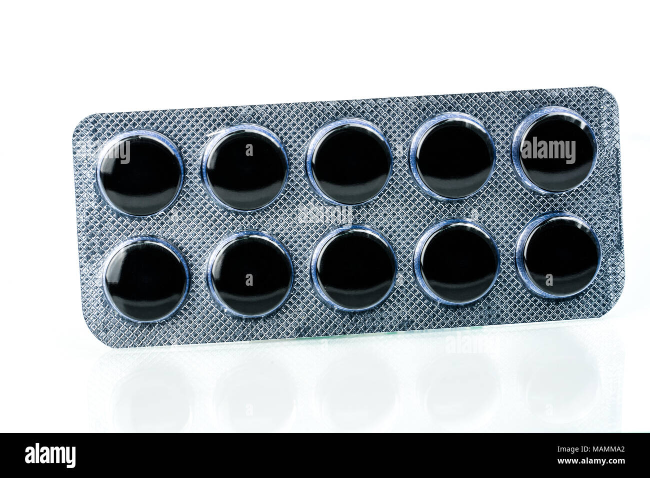 Carbone attivo pillole compresse in blister isolato su sfondo bianco con copia spazio per il testo. Nero tondo pillole per il trattamento avvelenamento da Foto Stock