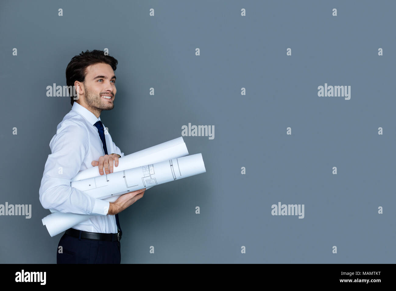 Gioioso uomo smart holding blueprints Foto Stock