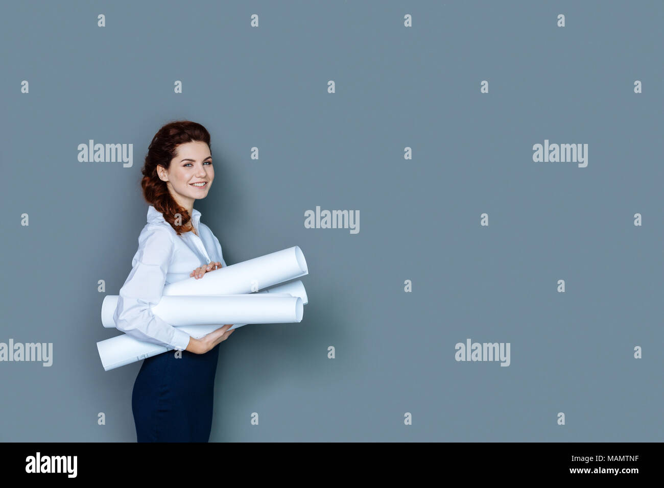 Allegra donna attraente essendo al lavoro Foto Stock