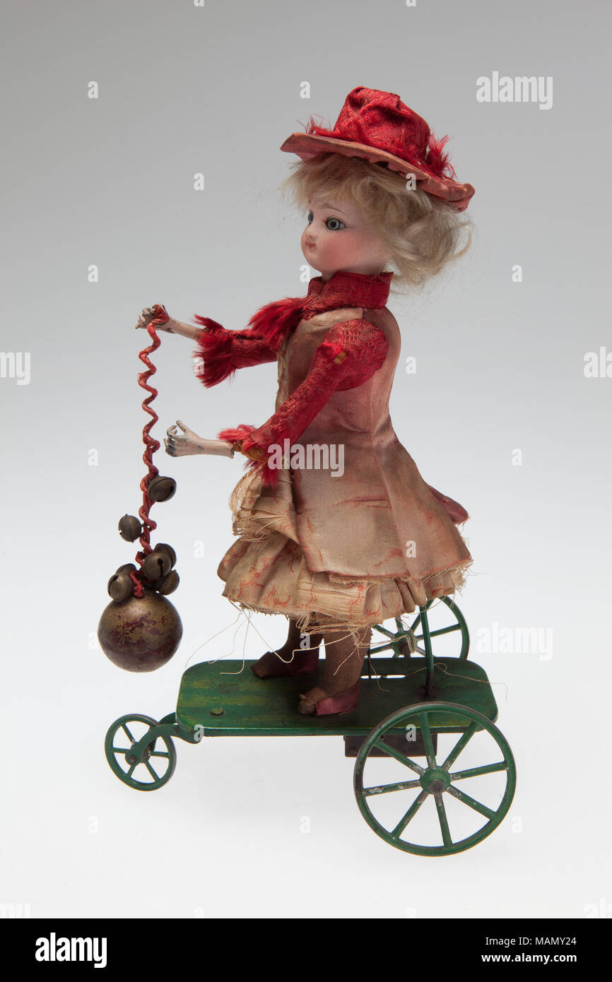 La precisione di un orologio meccanico doll su metallo piattaforma su ruote che suona un campanello e trasforma la sua testa come il meccanismo gira. Titolo: orologeria meccanica Doll squilla una campana . tra il 1870 e il 1900. Foto Stock