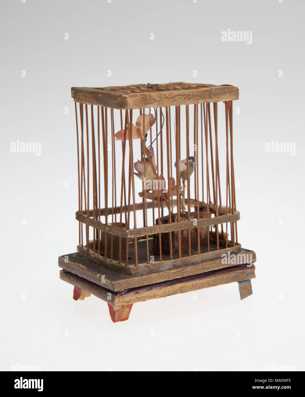 Squeaker giocattolo dotato di un piccolo uccello appollaiato all'interno di una gabbia di legno con un soffietto noisemaker. Titolo: Uccello Squeaker gabbia giocattolo . tra il 1875 e il 1900. Foto Stock