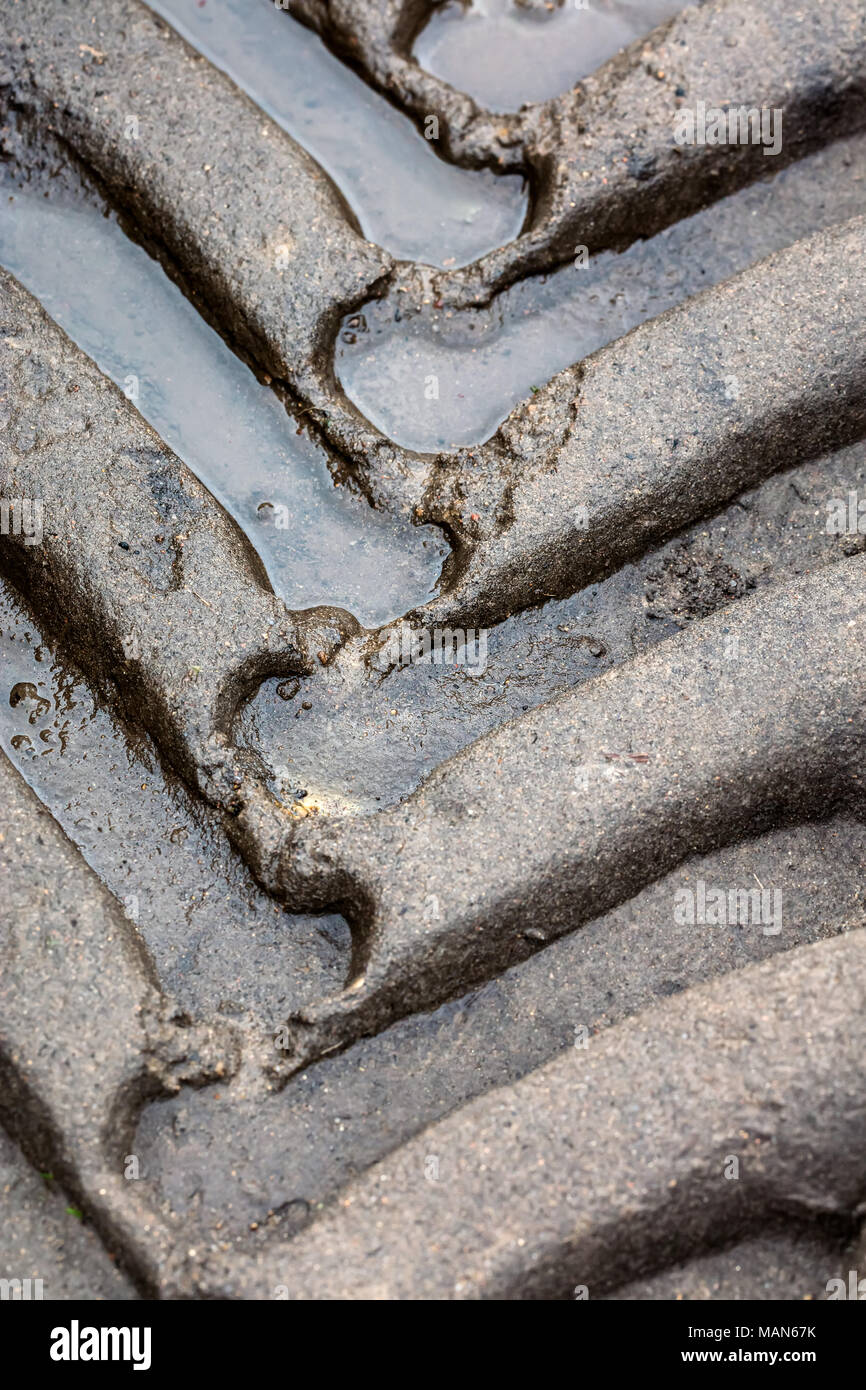 Tracce di pneumatici sulla strada fangosa in campagna. closeup vista dettagliata. Foto Stock