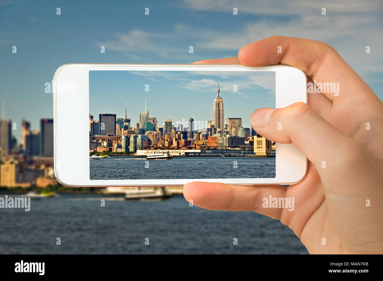 Primo piano di una mano con lo smartphone per scattare una foto della skyline di Manhattan, New York STATI UNITI D'AMERICA Foto Stock