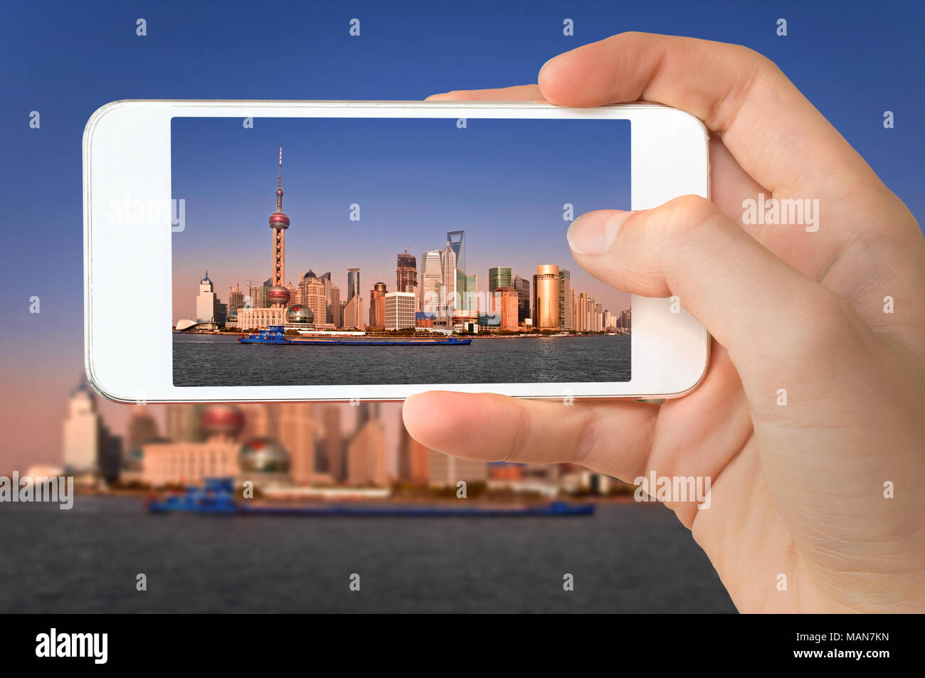 Primo piano di una mano con lo smartphone per scattare una foto della città di Shanghai e il fiume Huangpu, Cina Foto Stock