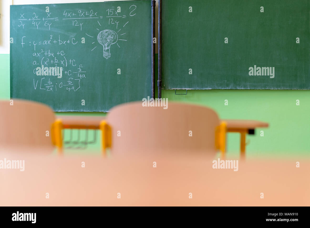 Svuotare la matematica aula con banchi di scuola, sedie e lavagna. Il concetto di istruzione. Foto Stock