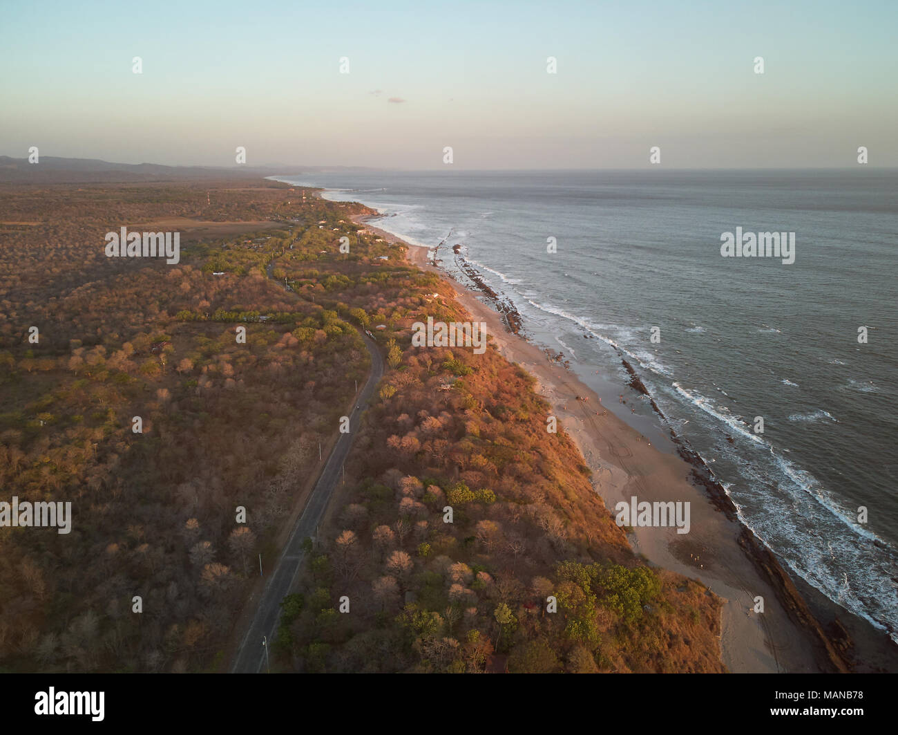 Fascia costiera sull'oceano al tramonto nel tempo. Spiaggia con strada vista aerea Foto Stock