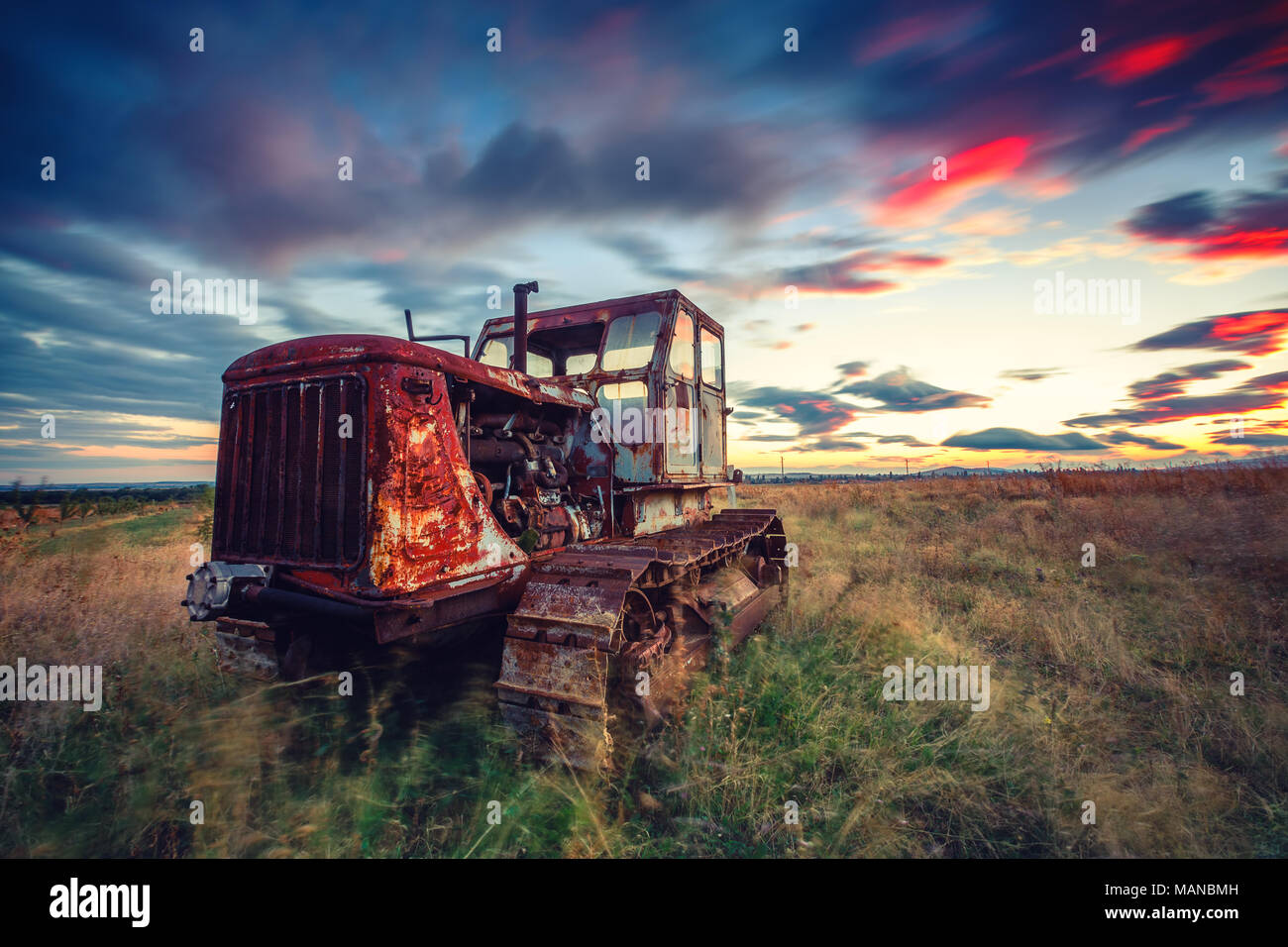 Bel tramonto su campo e vecchio trattore arrugginito. HDR Foto Stock