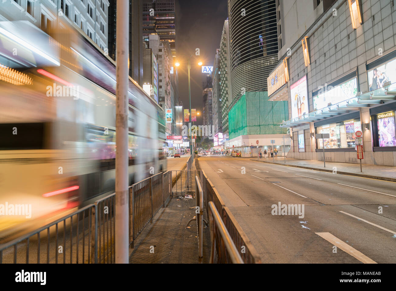 KOWLOON, HONG KONG - 19 settembre 2017; tipicamente città asiatiche street sotto le luci della notte la ricerca di Nathan Road come bus in motion blur passa nel centro cittadino Foto Stock