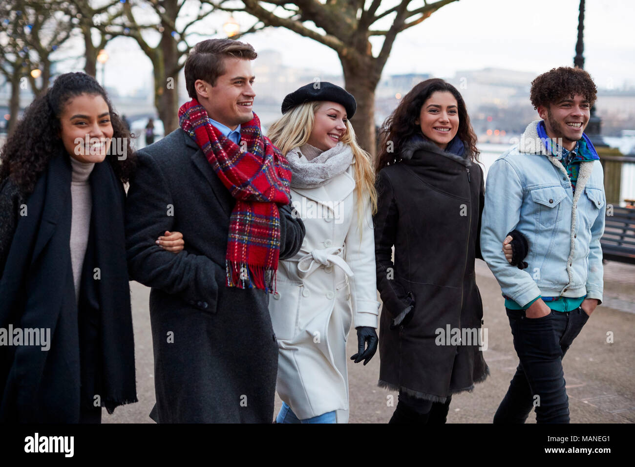 Gli amici passeggiando lungo South Bank sulla visita invernale a Londra Foto Stock