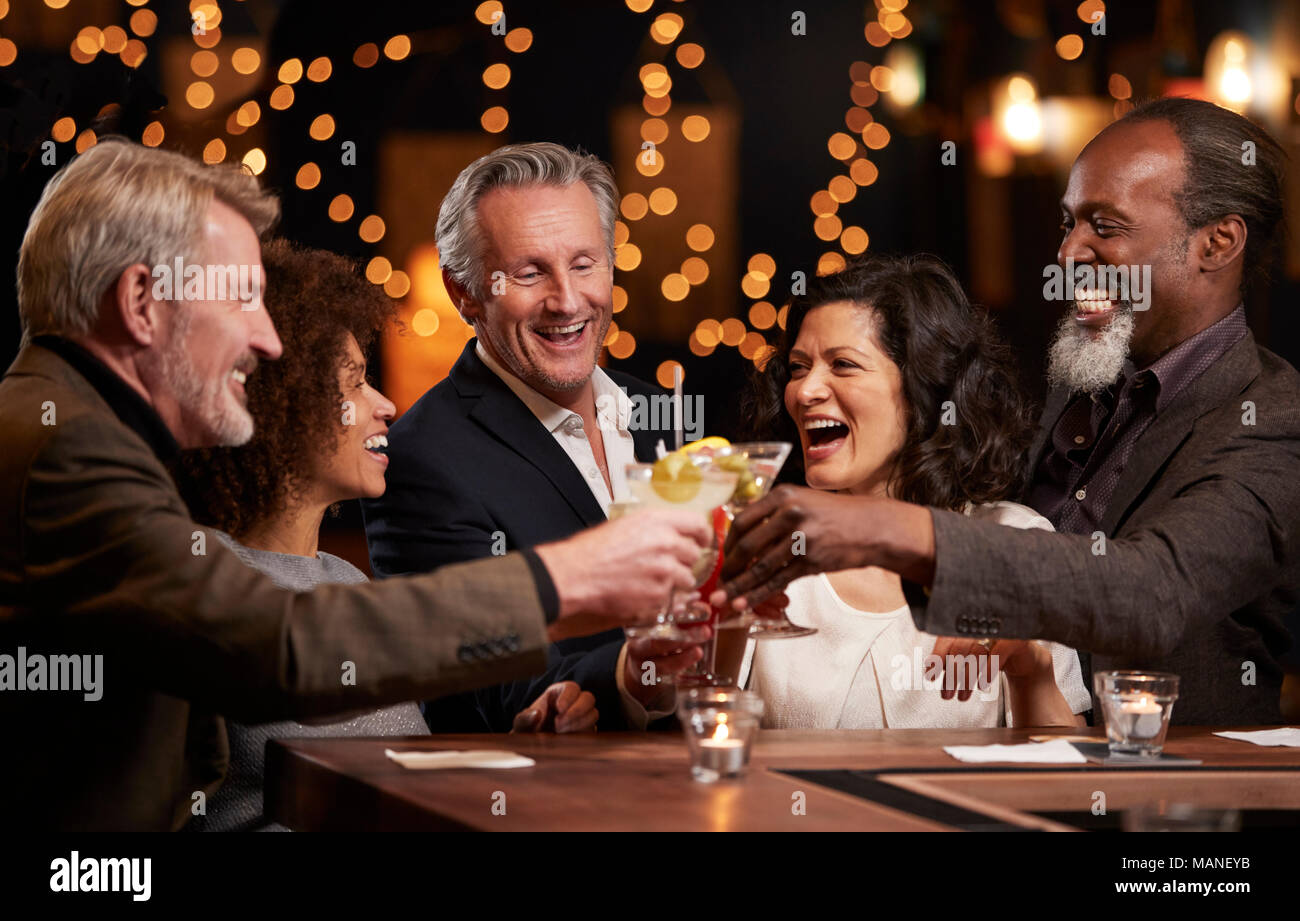 Un gruppo di persone di mezza età amici celebra nel Bar insieme Foto Stock
