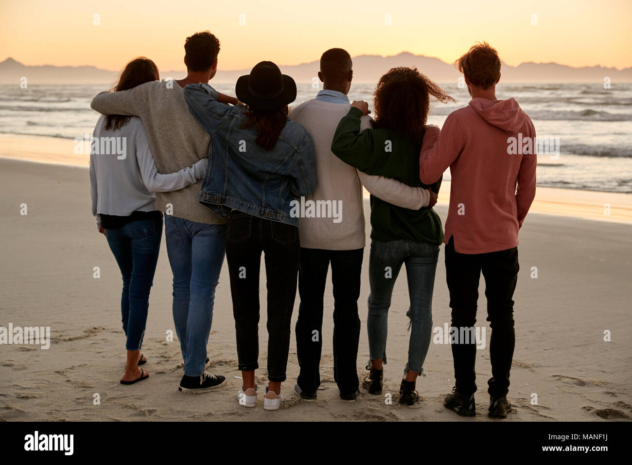 Gruppo di amici sulla Spiaggia Invernale la visione di insieme di Sunrise Foto Stock Gruppo di amici sulla Spiaggia Invernale la visione di insieme di Sunrise Foto Stock