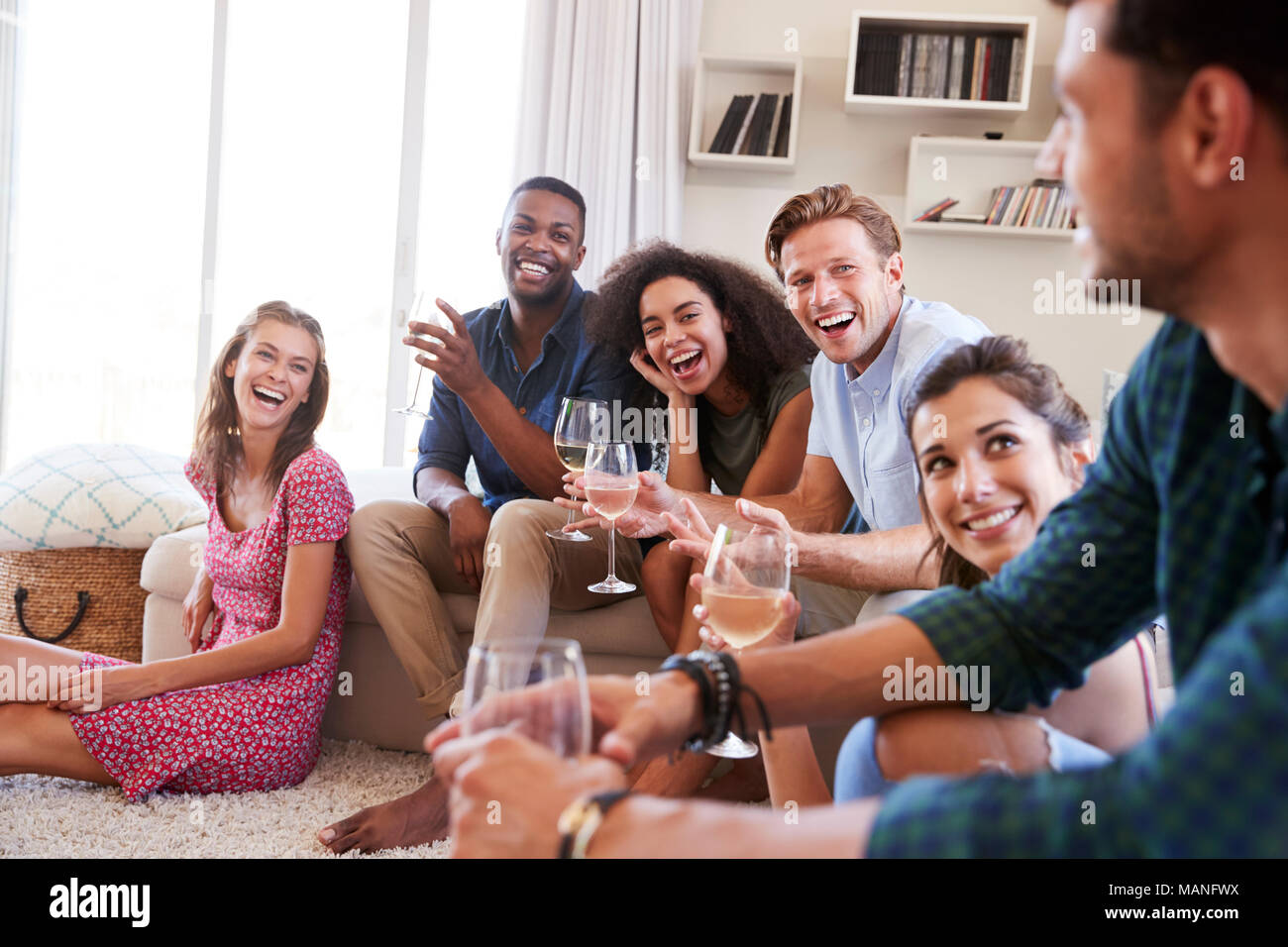 Gruppo di amici in un momento di relax a casa e bere il vino insieme Foto Stock