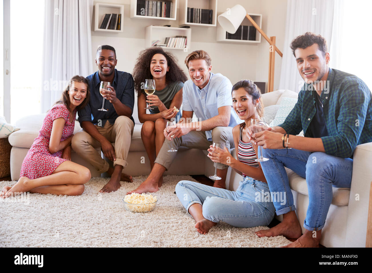 Ritratto di amici in un momento di relax a casa e bere il vino insieme Foto Stock