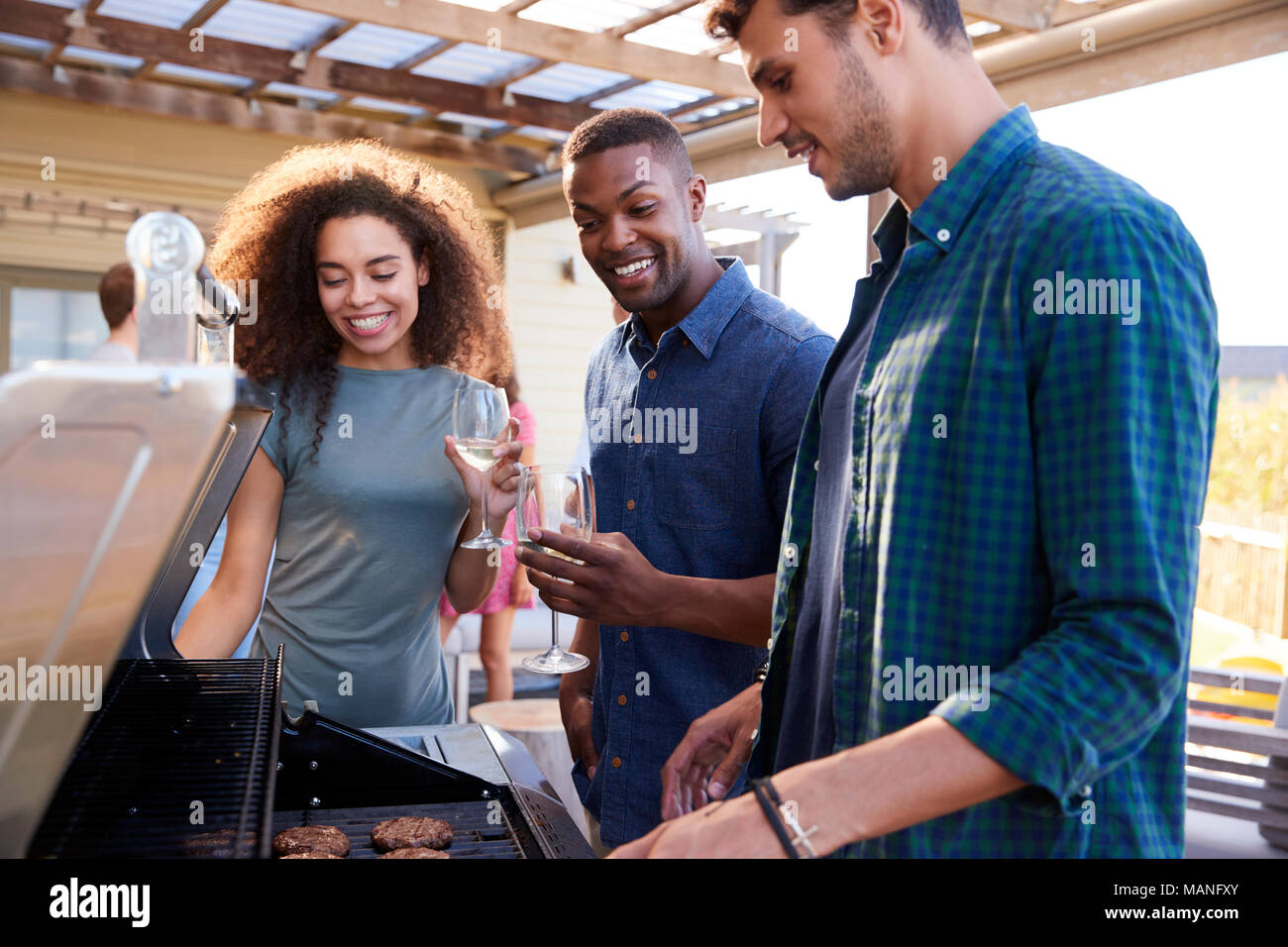 Gruppo di amici gustando un barbecue a casa insieme Foto Stock