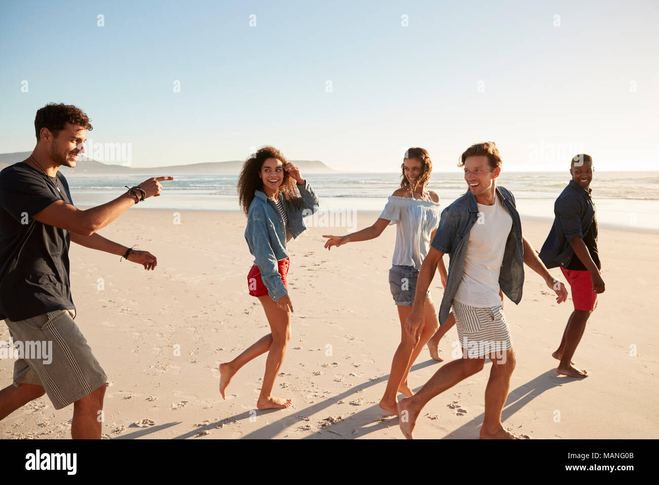 Gruppo di amici in vacanza a piedi lungo la spiaggia insieme Foto Stock