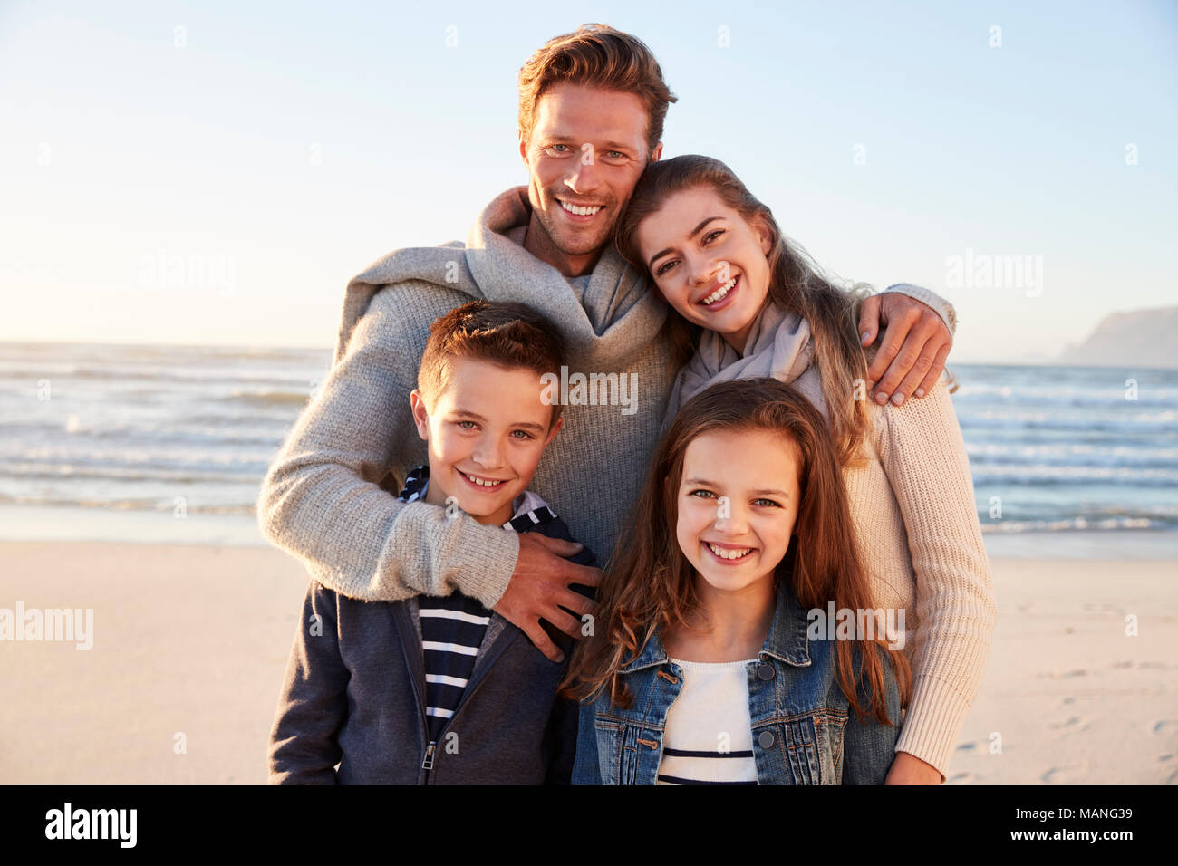 Ritratto di famiglia a piedi lungo la spiaggia invernale insieme Foto Stock