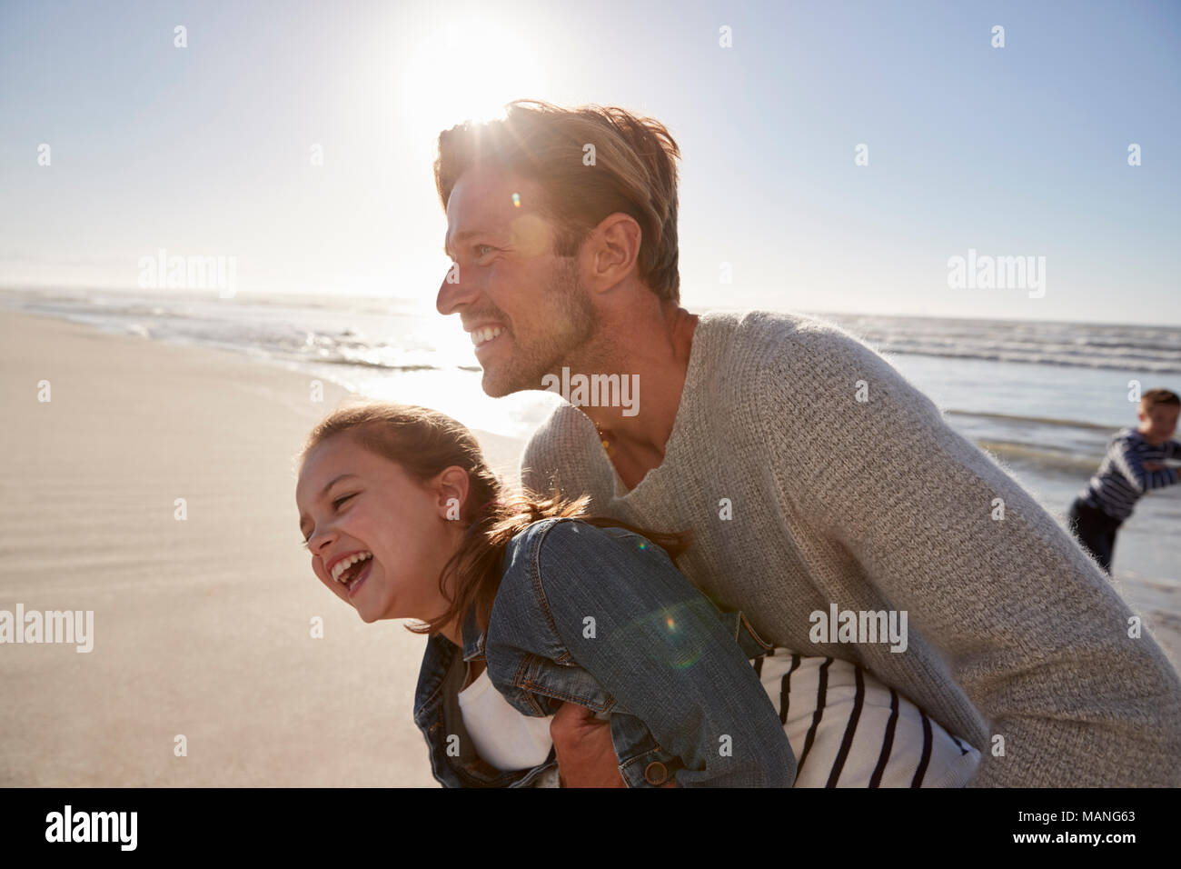 Padre con la figlia avendo divertimento sulla spiaggia invernale insieme Foto Stock