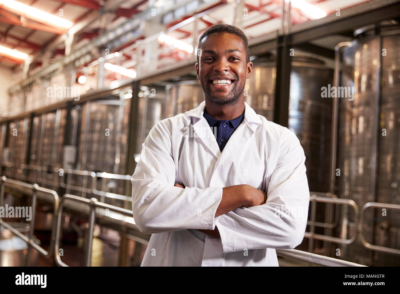 Giovane maschio nero fabbrica del vino tecnico sorridente alla fotocamera Foto Stock