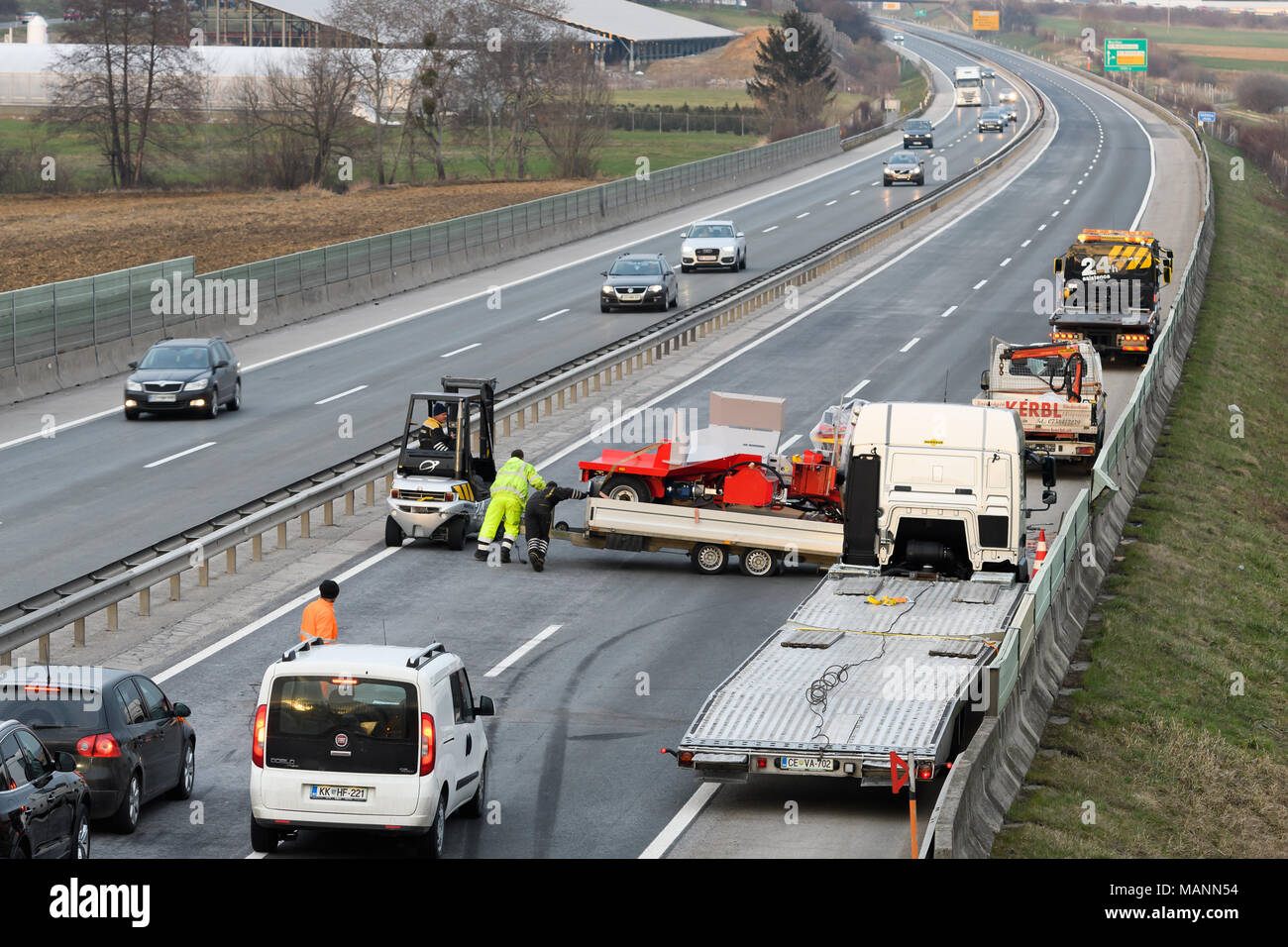 Trainare il carrello di pulizia dei lavoratori relitto da incidente di traffico su autostrada, i servizi di emergenza risposta Foto Stock