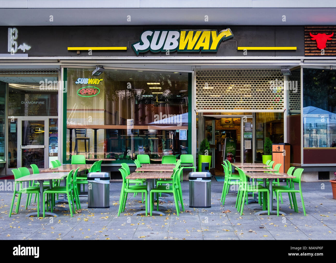 Berlino,Charlottenburg-Wilmersdorf, Subway fast food presa vende panini per mangiare o prendere-modo, Shop esterna e tavoli e sedie sul marciapiede della città Foto Stock