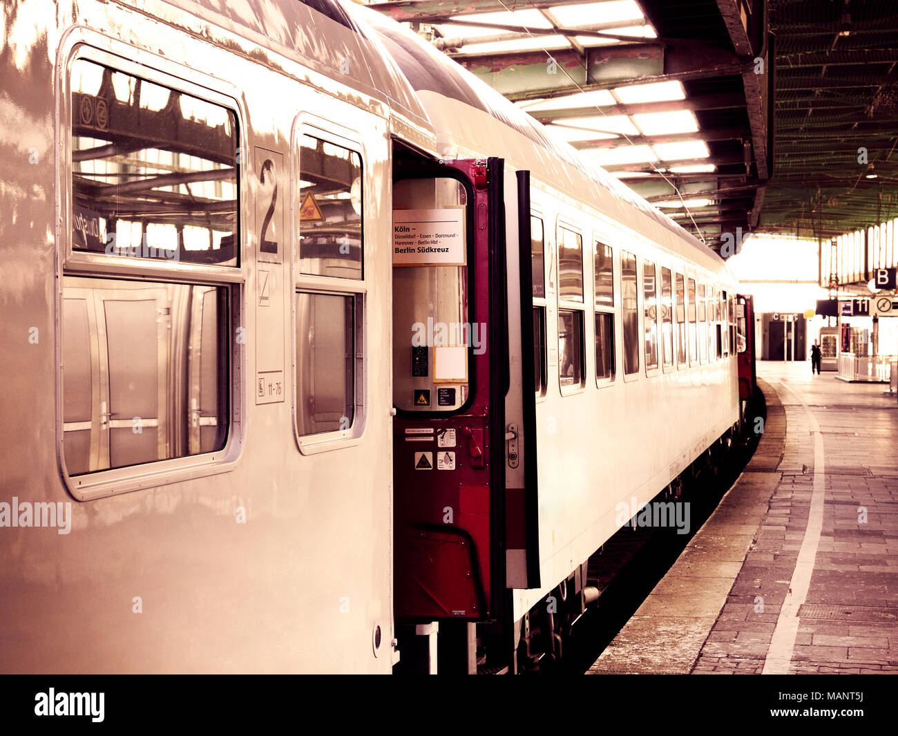 Il vecchio treno in una stazione ferroviaria con le porte aperte. Tonalità seppia immagine. Foto Stock