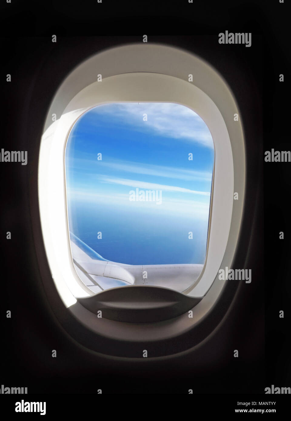 Aeroplano oblò, vista al di fuori di un aeroplano finestra al cielo blu e nuvole. Foto Stock