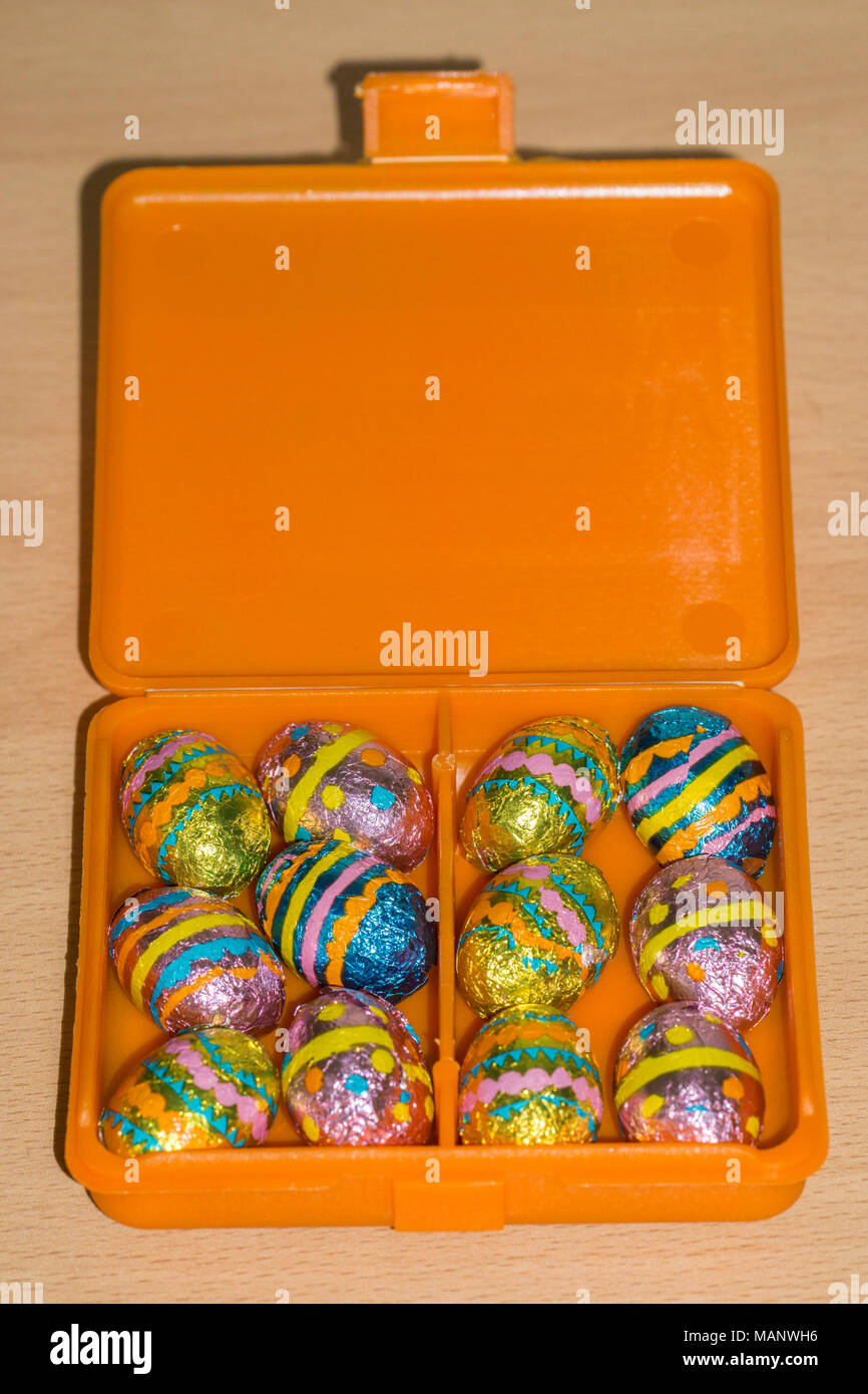 Carta metallizzata avvolto mini uova di pasqua di cioccolato nella casella Foto Stock