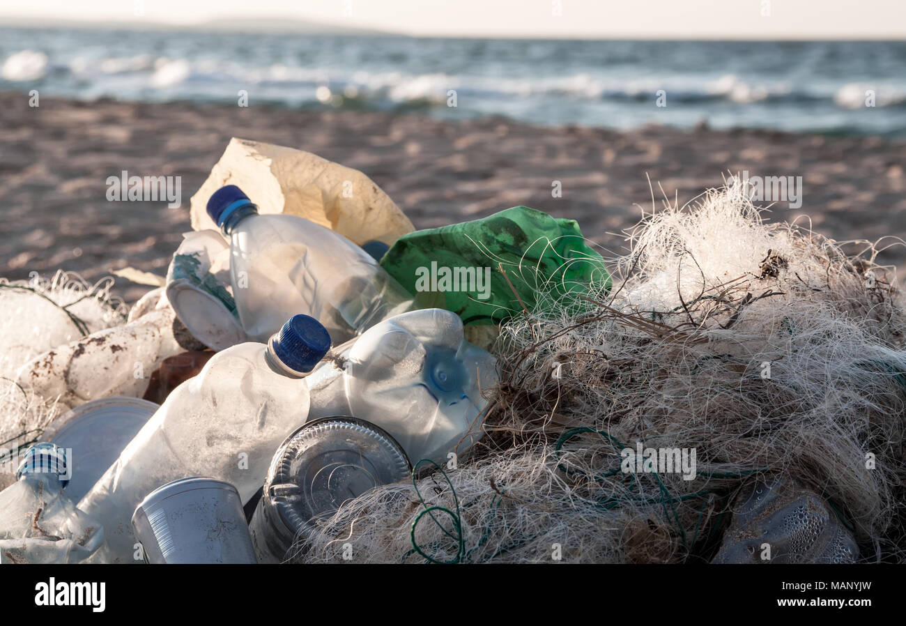 Spiaggia dell'inquinamento. Bottiglie di plastica e altri rifiuti sulla spiaggia del mare Foto Stock