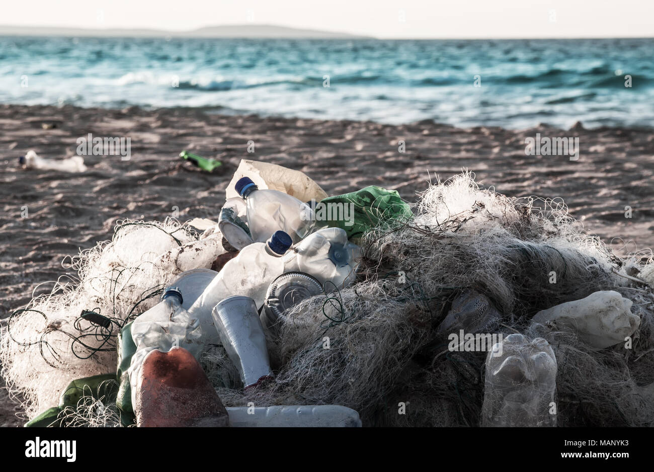 Spiaggia dell'inquinamento. Bottiglie di plastica e altri rifiuti sulla spiaggia del mare Foto Stock